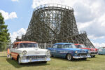 11 Four classic Chevrolet Tri Five cars parked on grass wooden roller coaster structure background