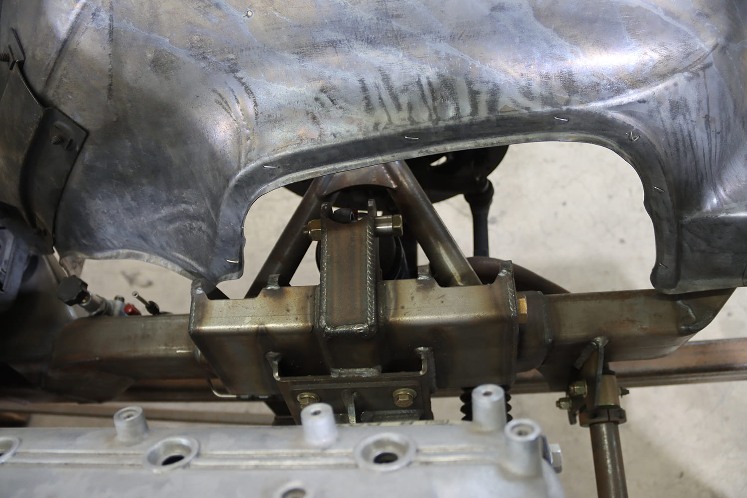 12 1967 Firebird front upper control arm crossbar mounted to boxed frame rail under bare wheel tub