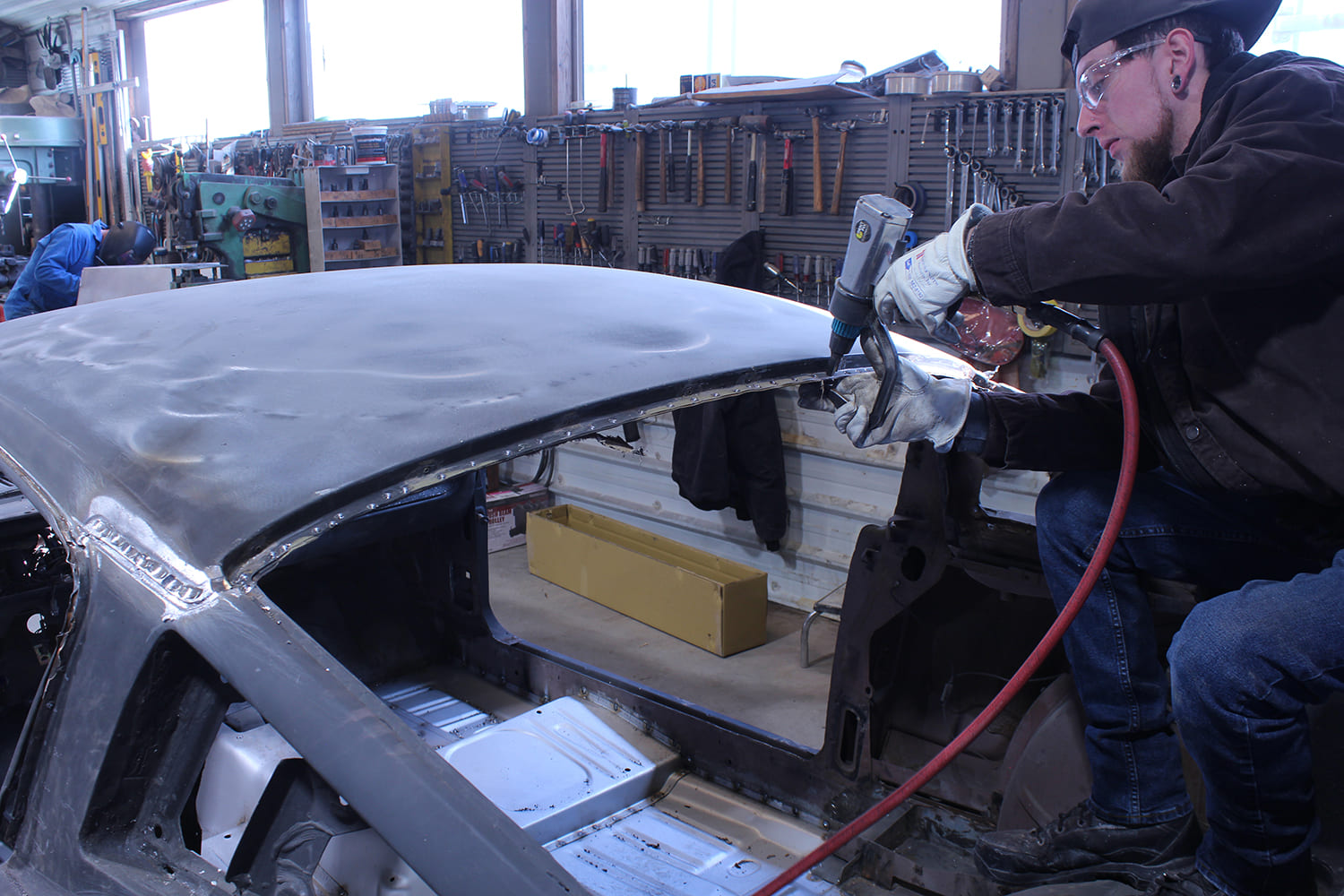 12 Spot welds are cut along roof flange using a pneumatic drill for panel separation