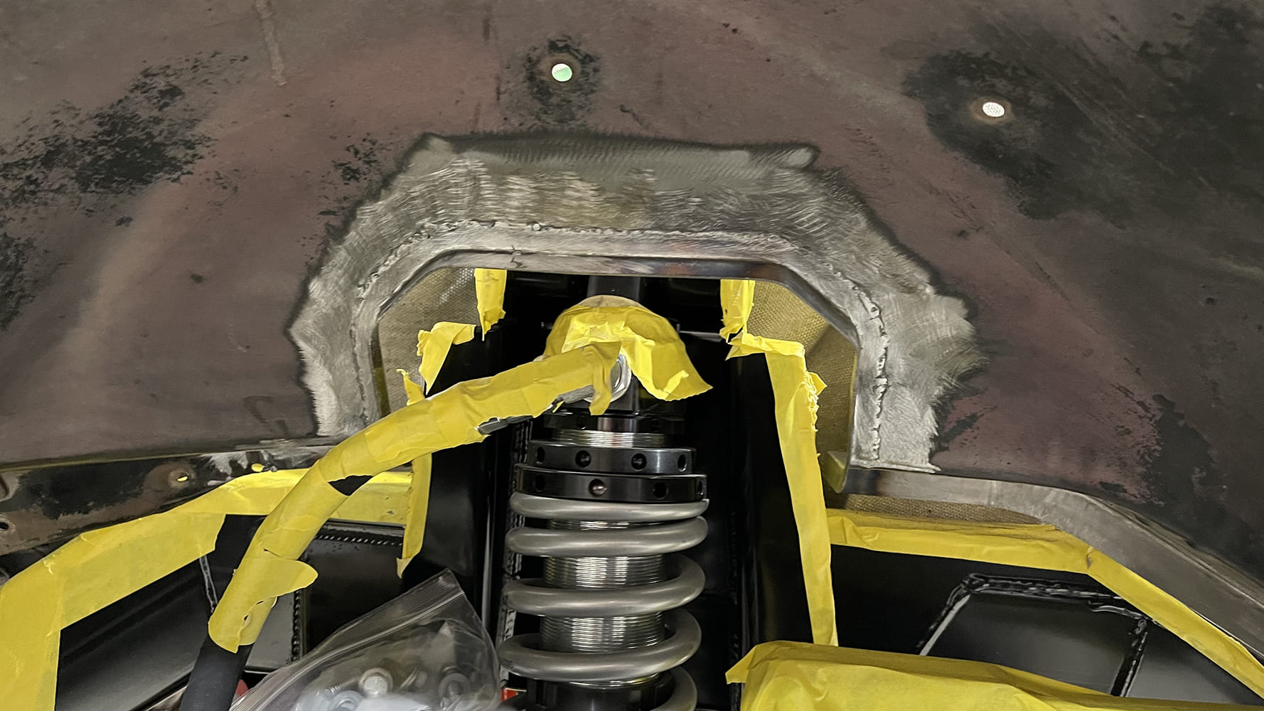 13 1985 chevy squarebody coilover shock mount welded into inner fender with raw finish and yellow tape