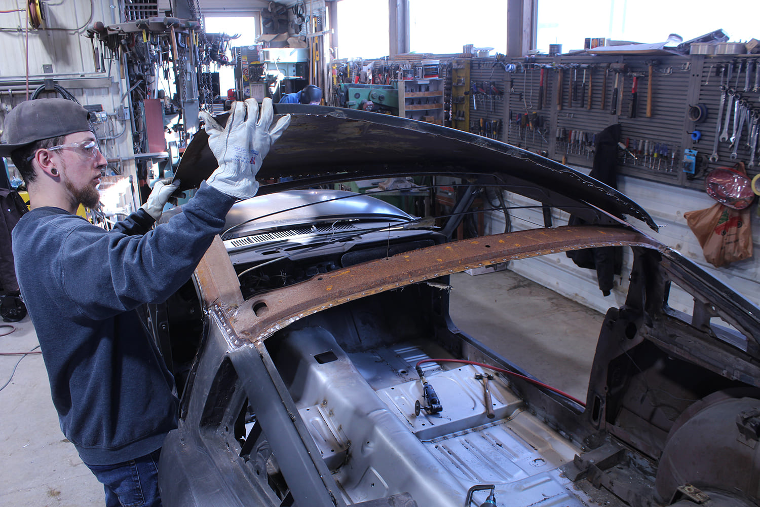13 Original roof skin is lifted off the '65 Mustang exposing inner structure and bow supports