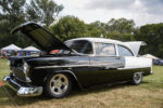 15 Black and white 1955 Chevrolet hood open chrome wheels car show setting