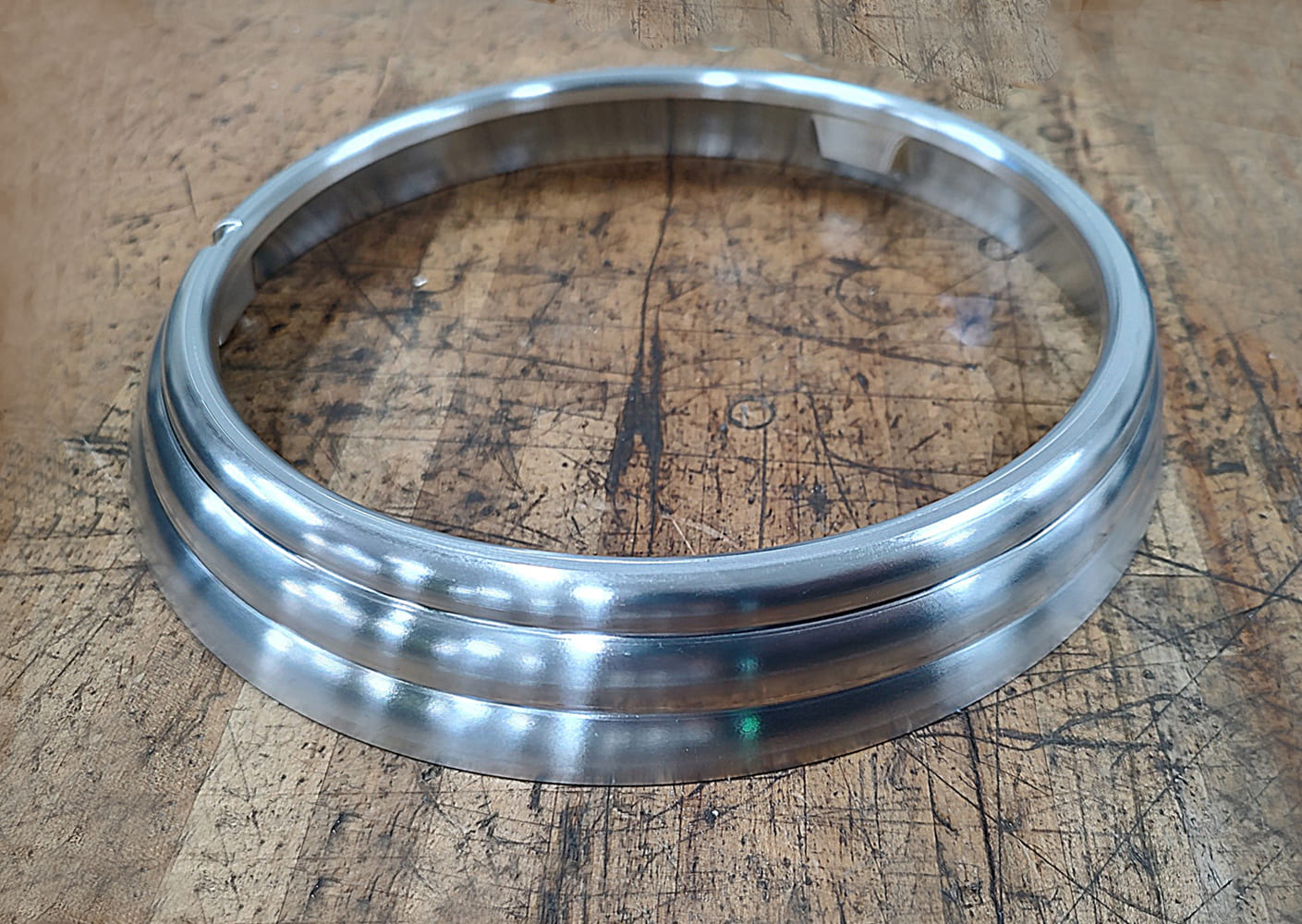 18 Divco headlight bezel in polished billet aluminum with stepped contours and mounting tabs