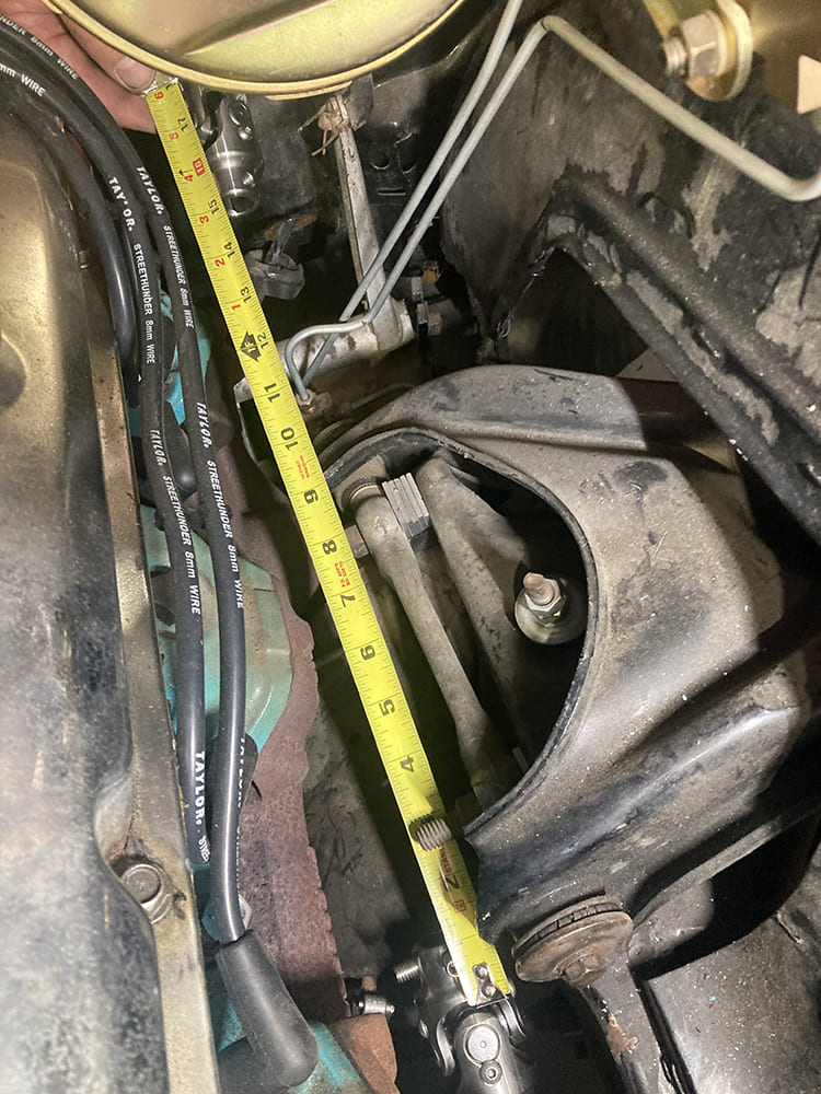 21 1964 Pontiac GTO measuring firewall to box for steering shaft fitment with tape against brake booster