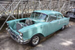 21 Turquoise 1957 Chevrolet with exposed engine dual carburetors under covered bridge structure