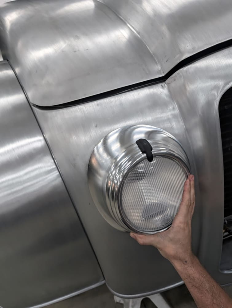 22 Divco headlight mockup test fit on front fender with lens and bucket held in place by hand