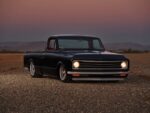03 1972 Chevrolet C10 front view black truck illuminated headlights dusk gravel field