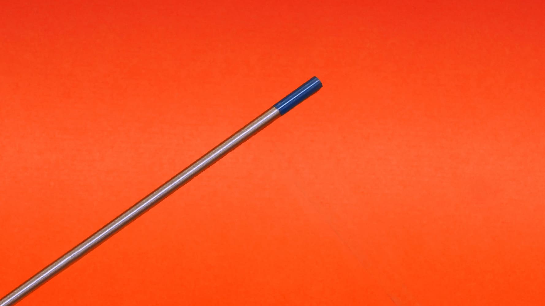 03 Single TIG tungsten electrode blue tip close up on orange background