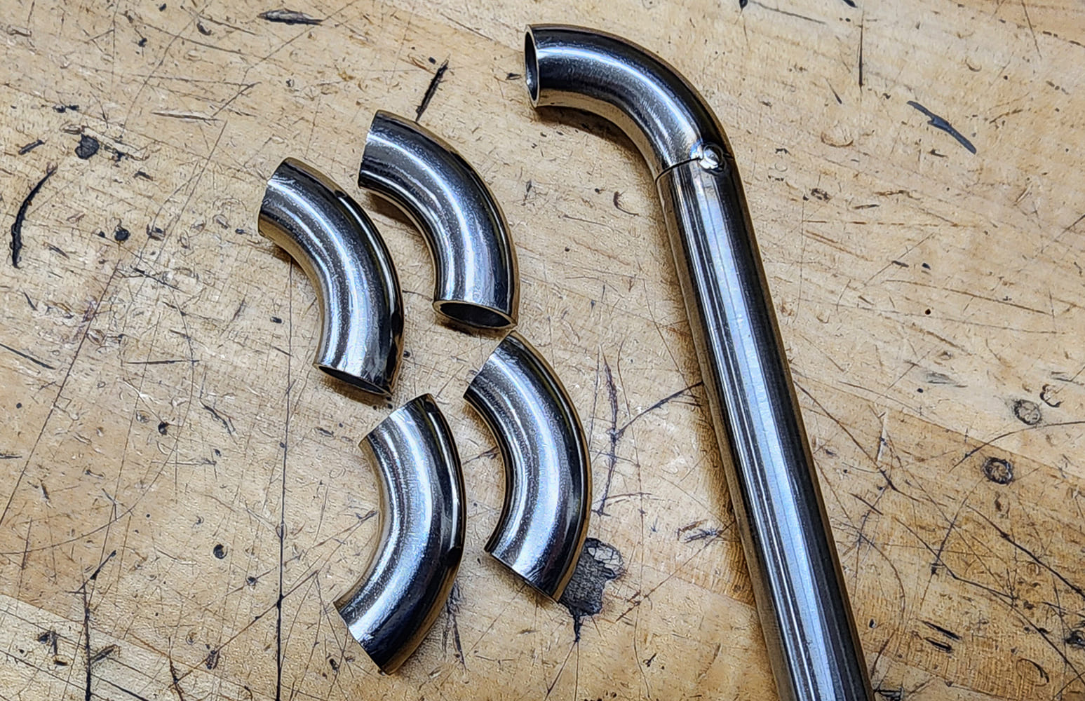 04 Short 90 degree stainless bends welded seam section wooden workbench