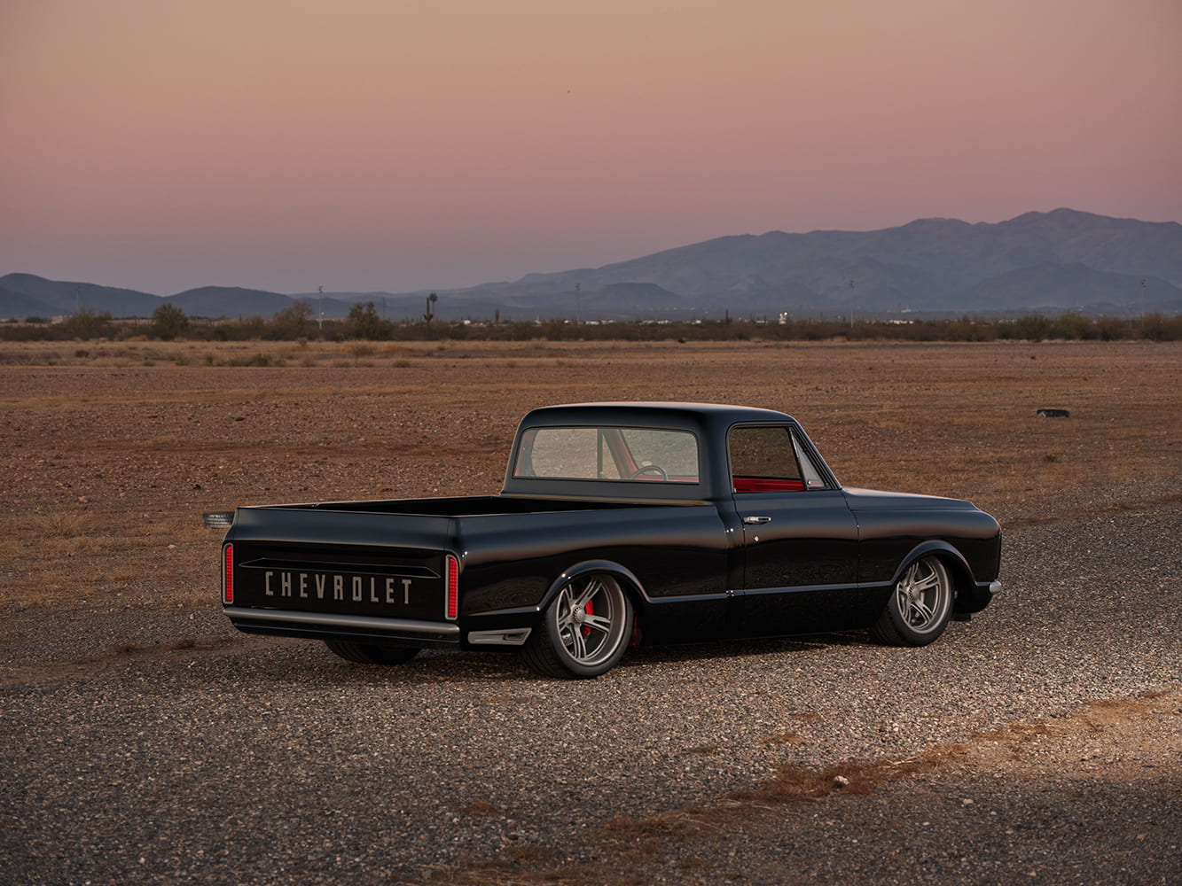 12 1972 Chevy C10 rear passenger side black truck red interior sunset desert