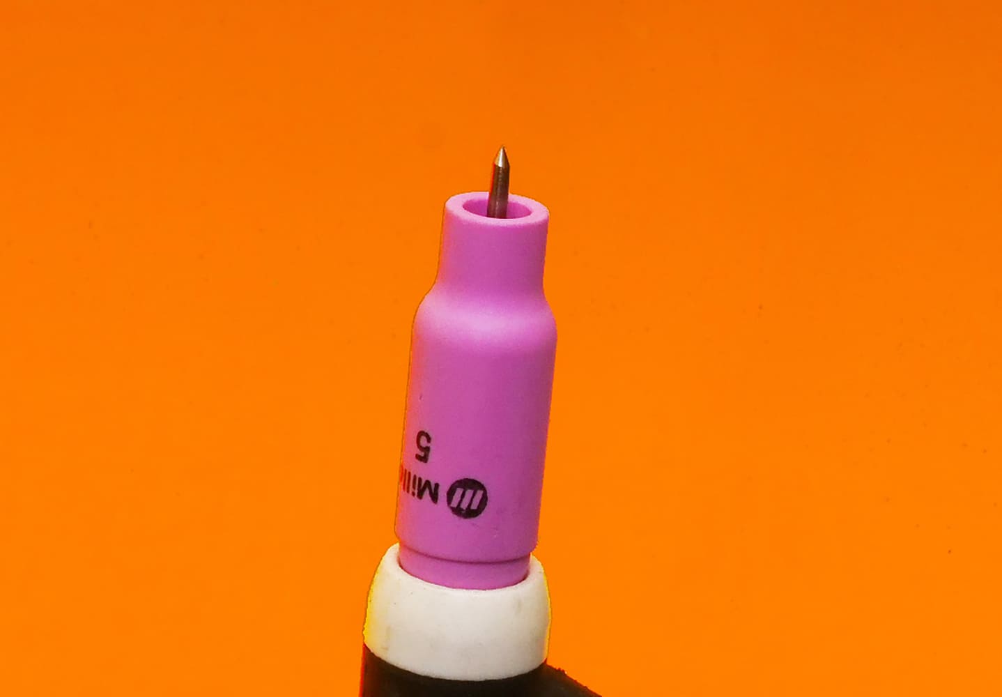 19 TIG torch with white ceramic cup tungsten tip protruding black handle partially visible orange background