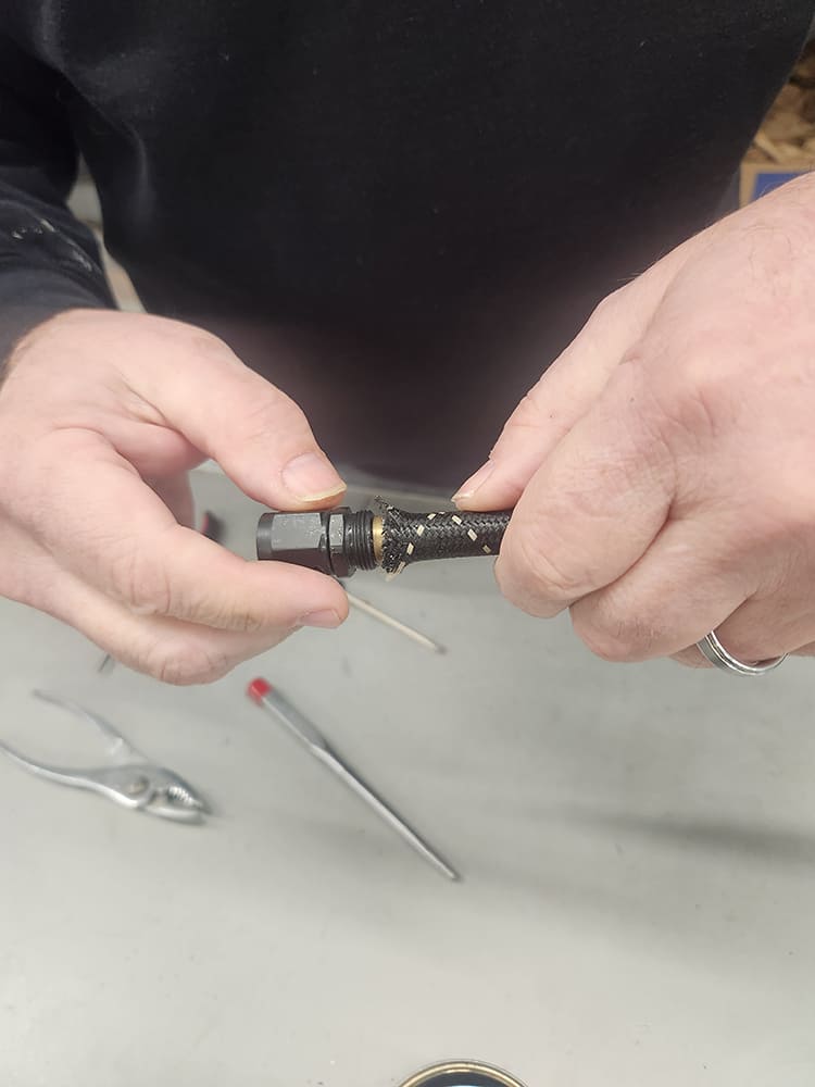 20 Threading AN hose collar onto brass insert with black fitting hand twist