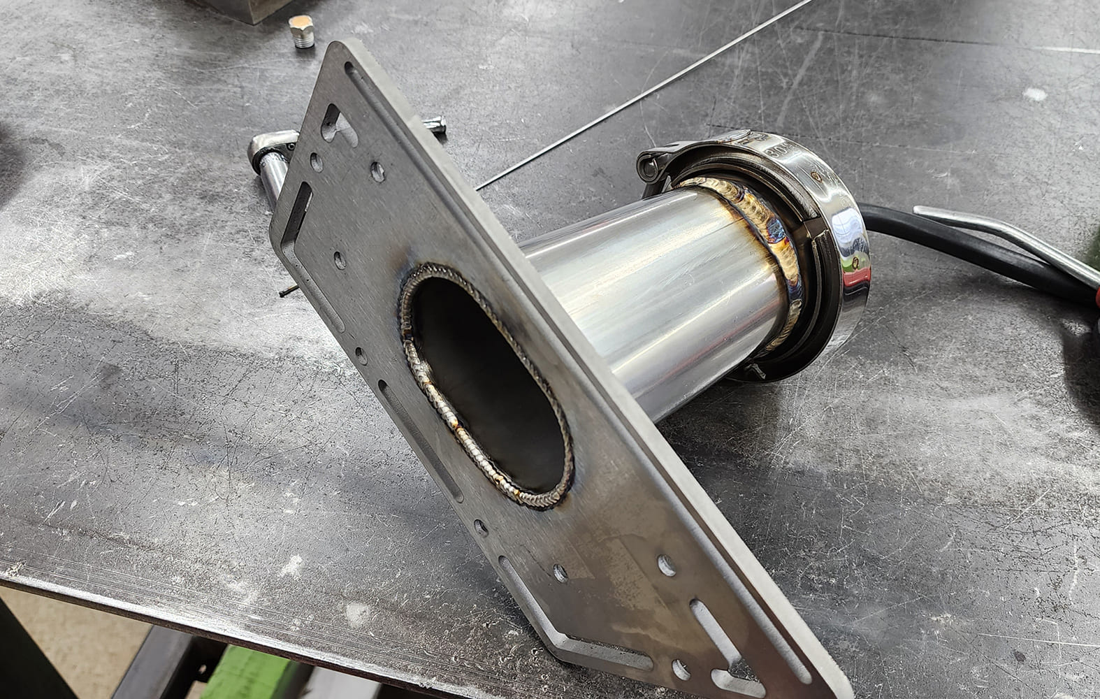 22 Stainless exhaust flange welded to mounting plate V band clamp fabrication fixture