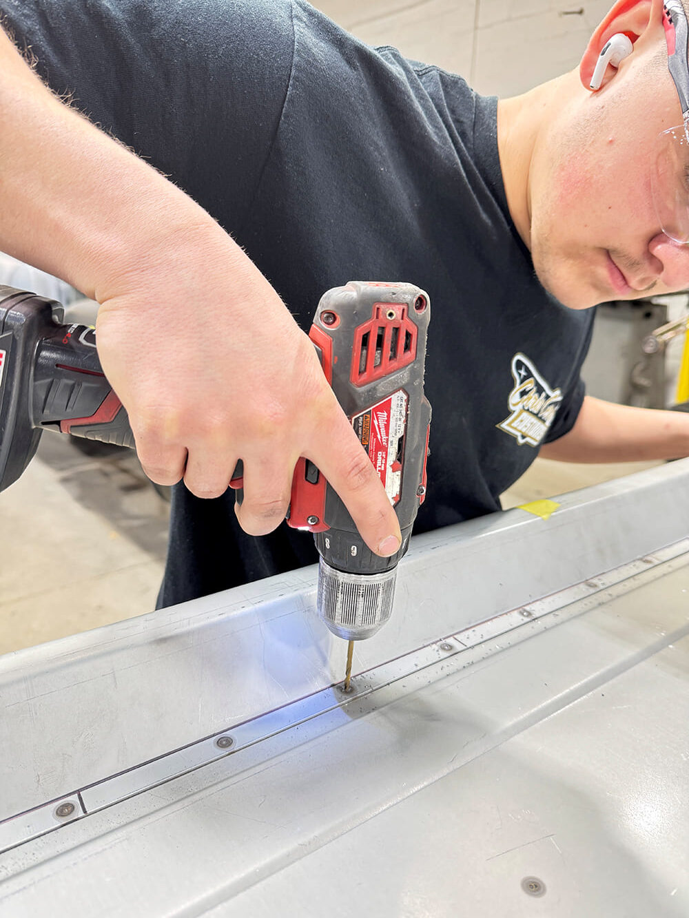 04 Drilling spot welds red Milwaukee drill tailgate reinforcing strip safety glasses and ear protection Club Carce Customs shirt