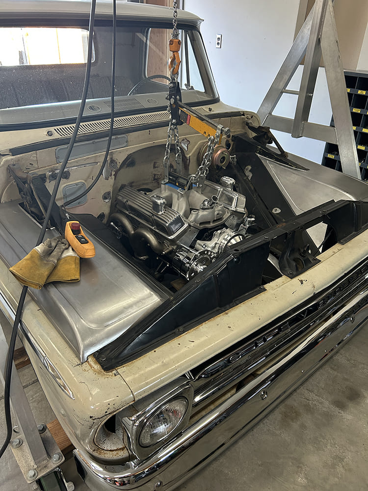 13 V8 engine being installed in engine bay custom metalwork 1960s Chevrolet C10 truck