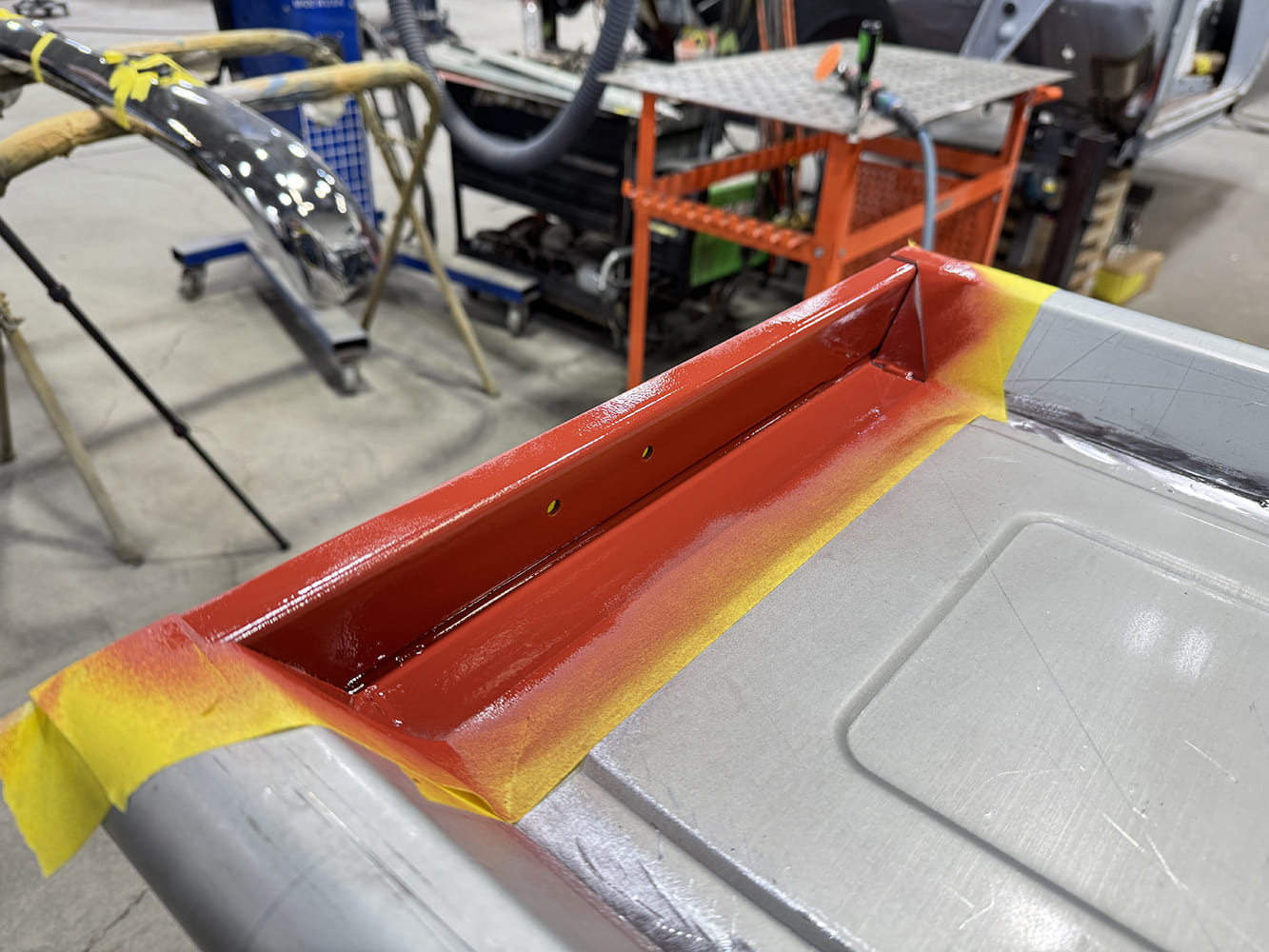 19 Red painted reinforcement panel yellow masking tape triangular gussets chrome bumper nearby