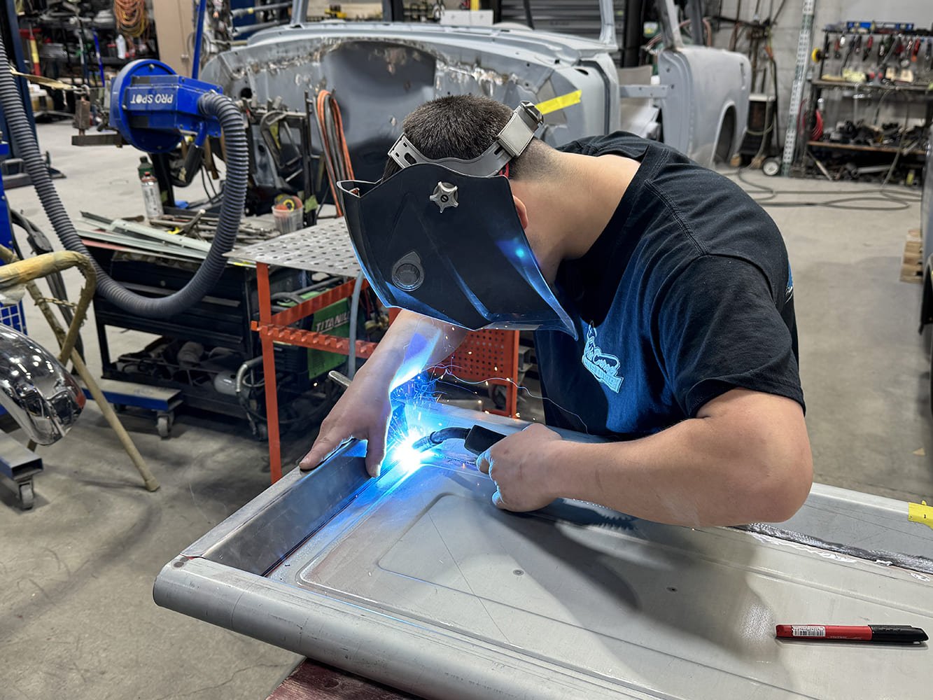 20 MIG welding inner edge helmet on clamps and marker on table shop racks
