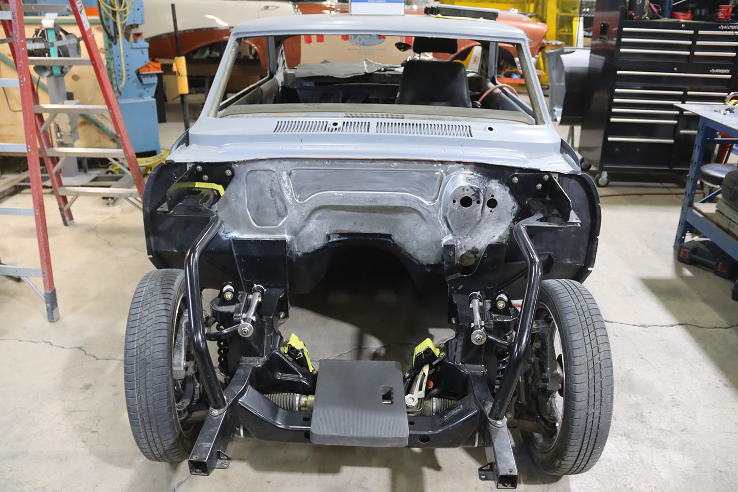 011 1967 Nova firewall smoothed with coilover front suspension and rack and pinion installed showing clean engine bay layout