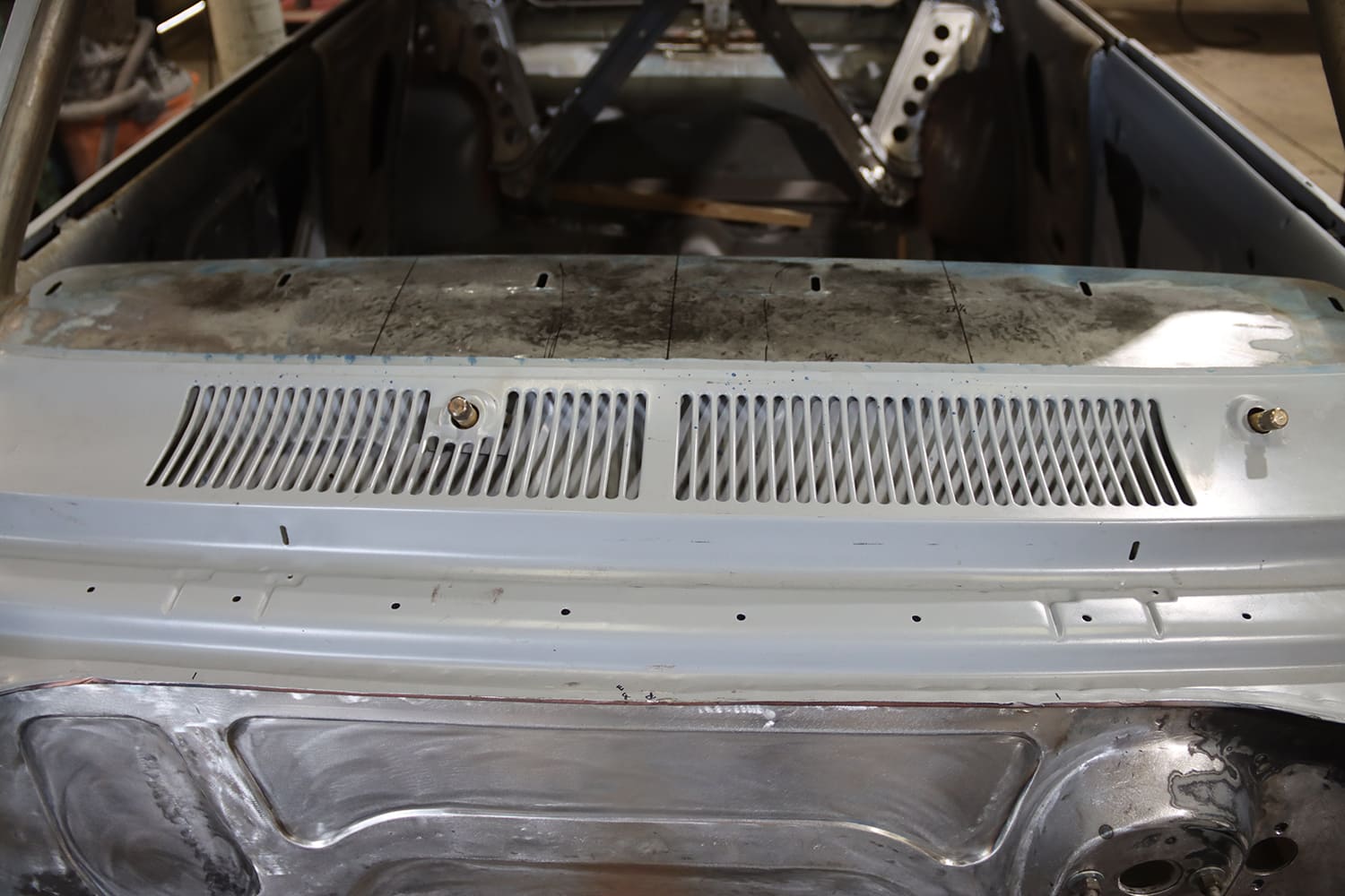 012 1967 Nova factory cowl vent before modification with original slotted grille and wiper post visible