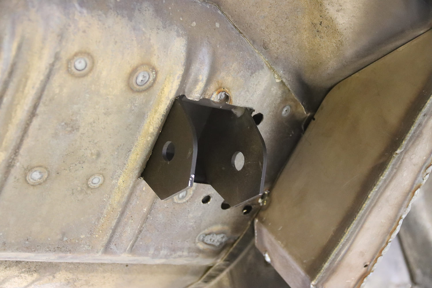 007 1963 Chevy Nova Welded rear lower control arm bracket tacked in place on factory floor structure
