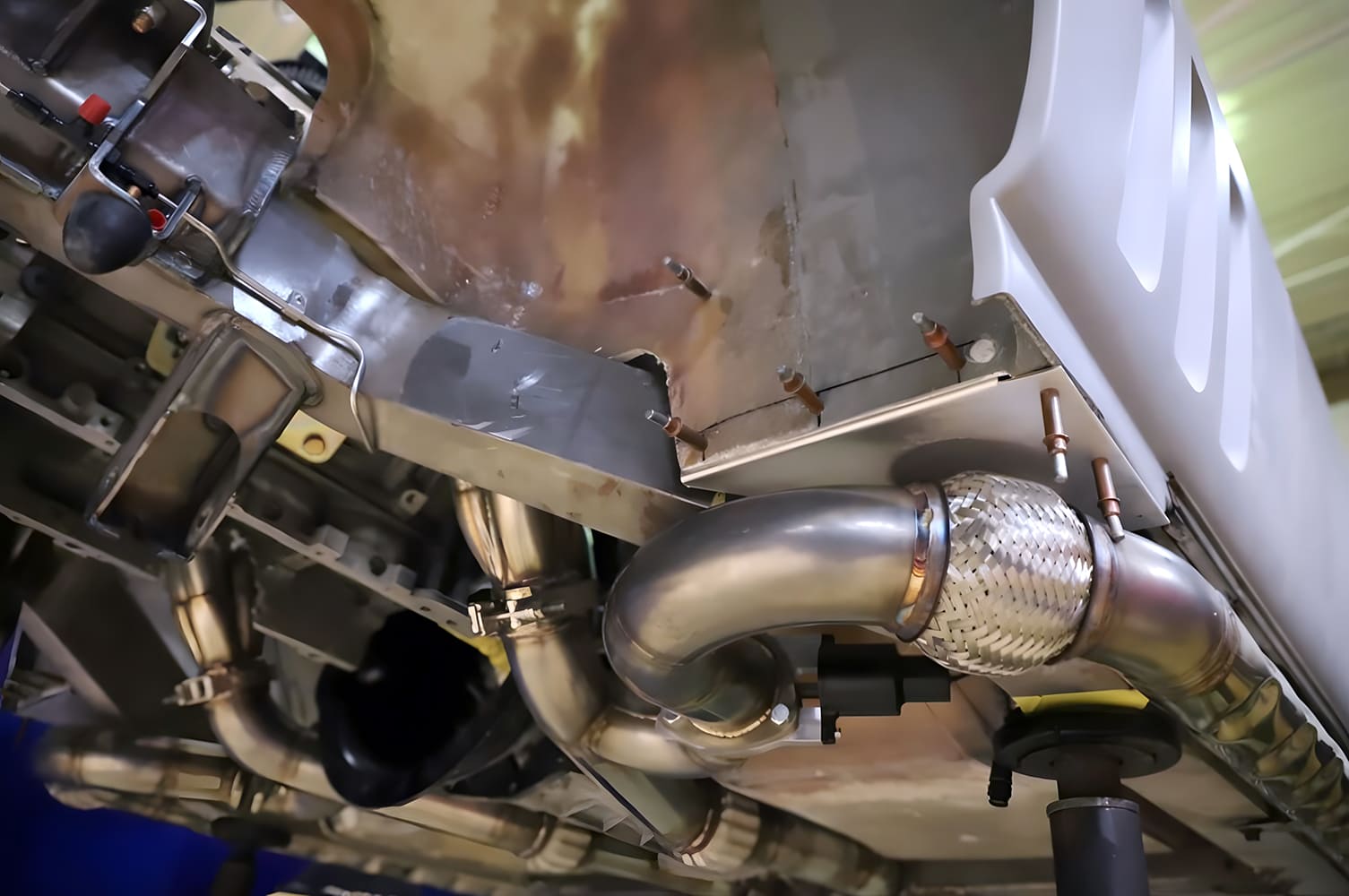 corvette custom flex section and exhaust exit routed past rear suspension mounting and custom fab work