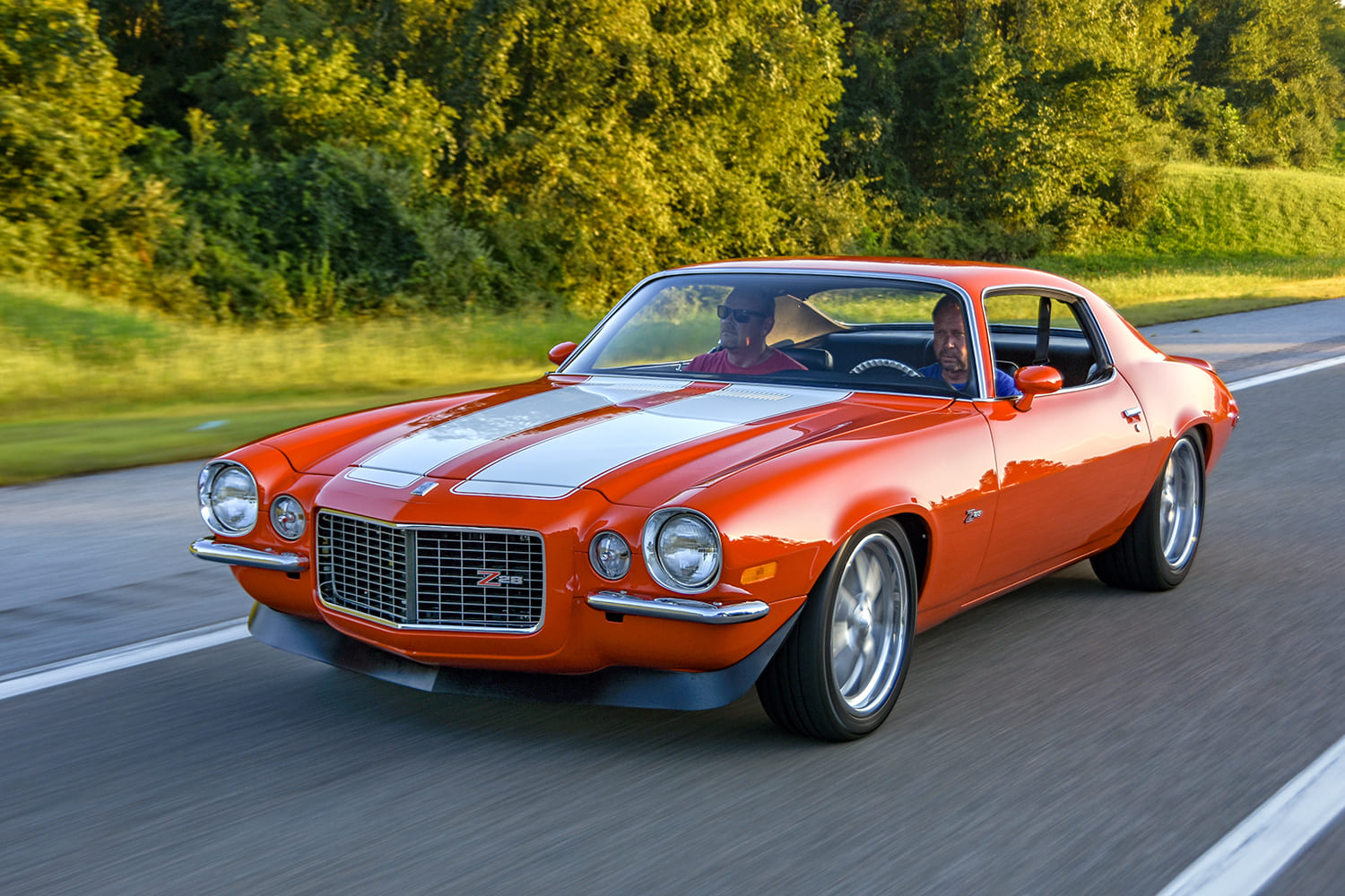 70 camaro z28 orange driving front three quarter pro touring muscle car road action