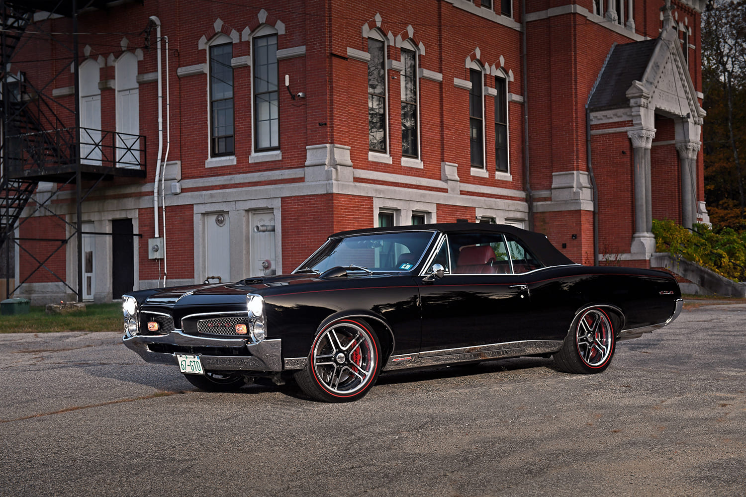 04 1967 Pontiac GTO black convertible restomod front three quarter view headlights on classic muscle car