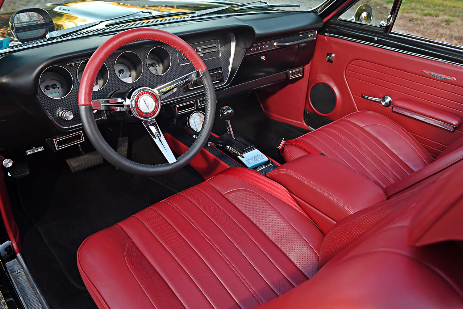 67 Pontiac GTO red dashboard gauges steering wheel detail