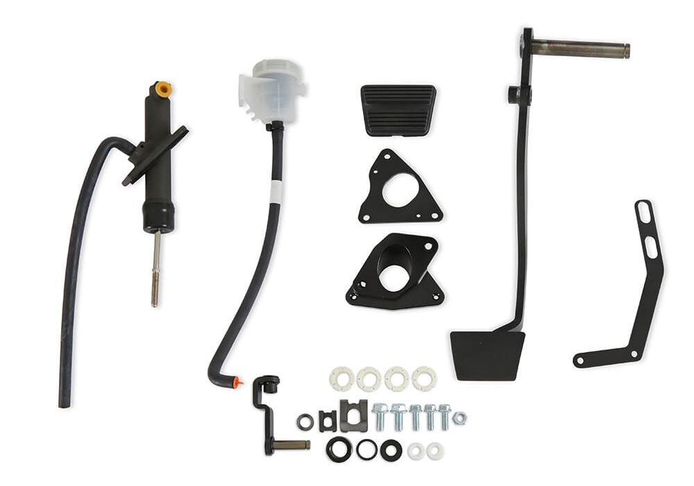 Holley hydraulic clutch conversion kit components laid out flat, including clutch pedal assembly, master cylinder, fluid reservoir, bracket plates, and mounting hardware.