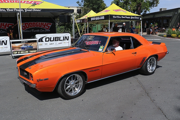 Front three-quarter view of Montie Hurd’s Hugger Orange 1969 Chevrolet Camaro RS Z28 driving past the Goodguys tent at the Goodguys Pleasanton West Coast Nationals.