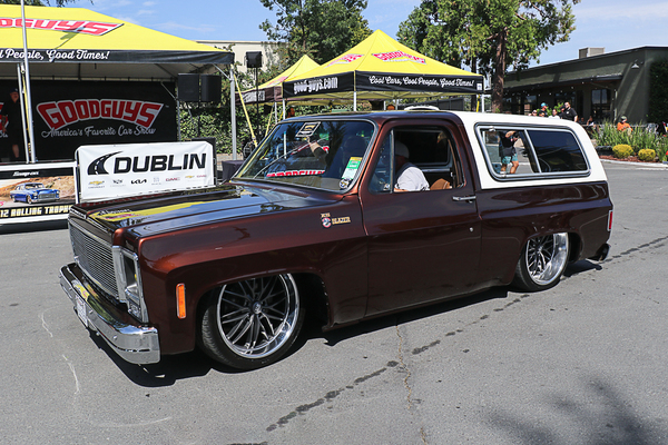 Front three-quarter view of Johnny Cagle’s bagged metallic root beer and white 1978 Chevrolet K5 Blazer driving past the Goodguys tent at the Goodguys Pleasanton West Coast Nationals.