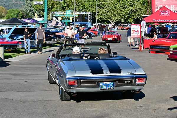 Rear view of a silver 1970 Chevrolet Chevelle SS convertible with black racing stripes cruising through the show grounds at the Goodguys Pleasanton West Coast Nationals.