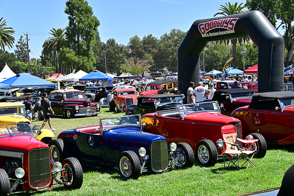 Lineup of custom 1932 Ford roadsters parked on the grass beneath the giant inflatable Goodguys Rod & Custom Association arch at the Goodguys Pleasanton West Coast Nationals.