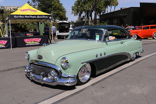 Front three-quarter view of a two-tone seafoam green and dark green 1953 Buick Super hardtop cruising past the Goodguys tent at the Goodguys Pleasanton West Coast Nationals.