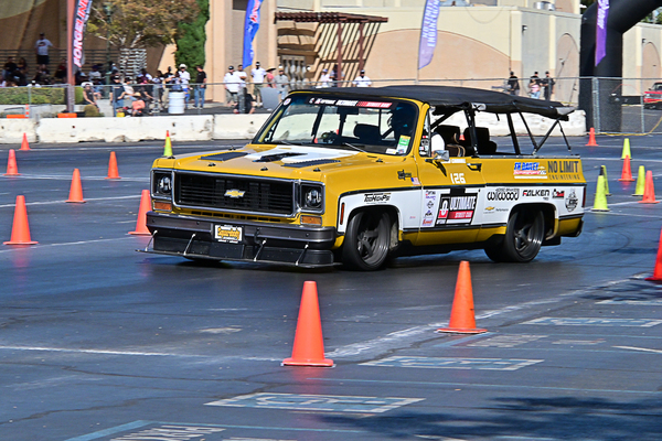 Front three-quarter view of the No Limit Engineering #126 yellow and white Chevrolet K5 Blazer autocross racer navigating the cone course at the Goodguys Pleasanton West Coast Nationals.
