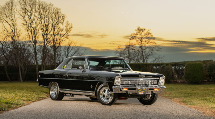 Front three-quarter angle of a glossy black 1966 Chevrolet Nova Super Sport restomod with chrome wheels parked on an asphalt road at sunset.