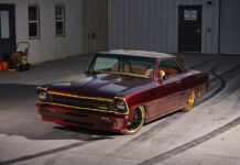 Pro Touring Style 1967 Nova Restomod Custom 1967 Chevrolet Chevy II Nova restomod in deep candy apple red paint with gold accents and custom wheels parked outside a workshop.