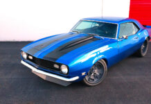 High-angle front three-quarter view of a bright blue 1968 Chevrolet Camaro SS restomod with black cowl stripes and custom gray wheels.