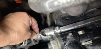 Hand aligning the lower universal joint and polished Double D shaft onto the steering box splines next to the tubular control arm mount.