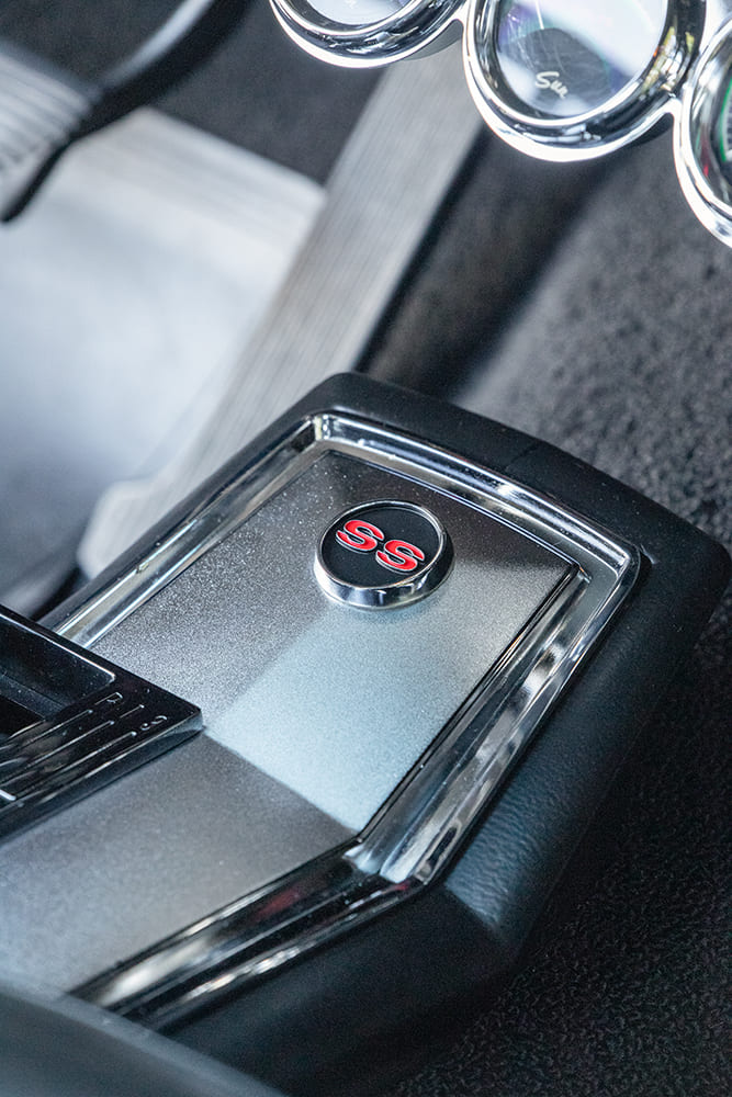 Macro view of the chrome and brushed metal center console insert featuring a circular red and chrome SS Super Sport emblem.
