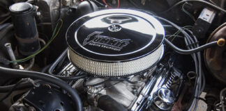 Overhead view of the finished small-block Chevy engine bay showcasing the round chrome Summit air cleaner, matching chrome valve covers, and tidy hose routing.