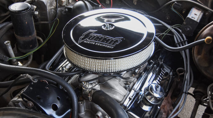 Overhead view of the finished small-block Chevy engine bay showcasing the round chrome Summit air cleaner, matching chrome valve covers, and tidy hose routing.