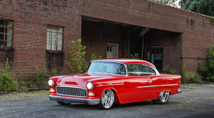 Alan Bates’ 1955 Chevy Bel Air is Classically Modern Slammed 1955 Chevy Bel Air coupe in gloss red paint parked on pavement outside an industrial brick warehouse.