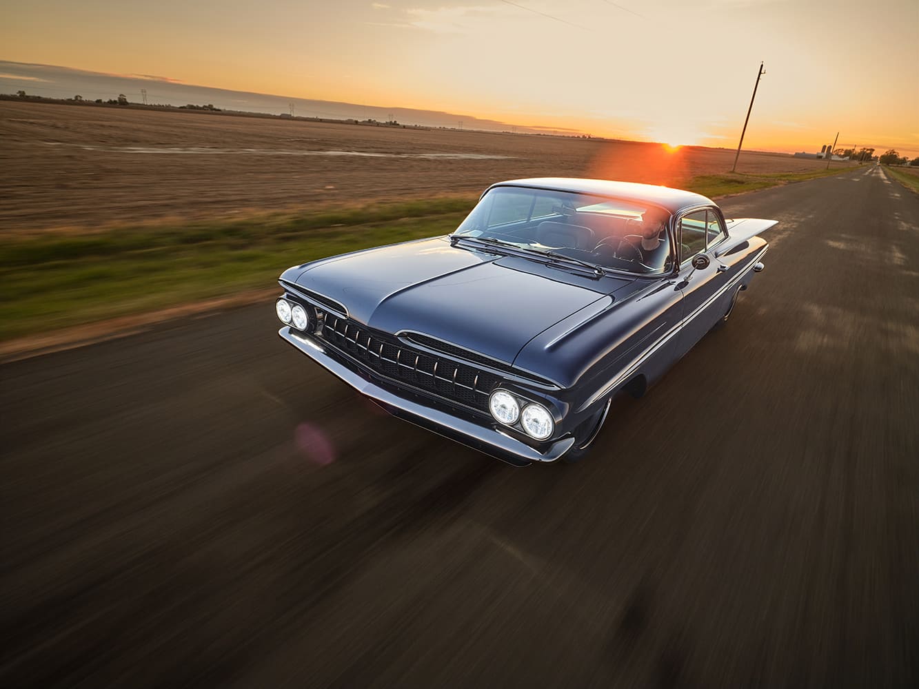 1959 Chevrolet Impala front three quarter rolling shot sunset highway chrome grille quad headlights custom coupe
