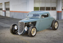 A Father’s Blueprint Becomes a Son’s 1933 Ford Coupe Low-angle front view of a slate blue-teal chopped 1933 Ford 3-Window Coupe highlighting the exposed front suspension and open engine bay.