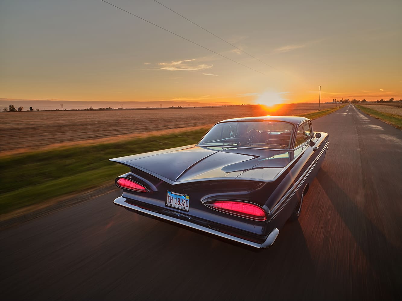1959 Chevrolet Impala rear three quarter rolling shot sunset road glowing taillights dramatic tailfins custom