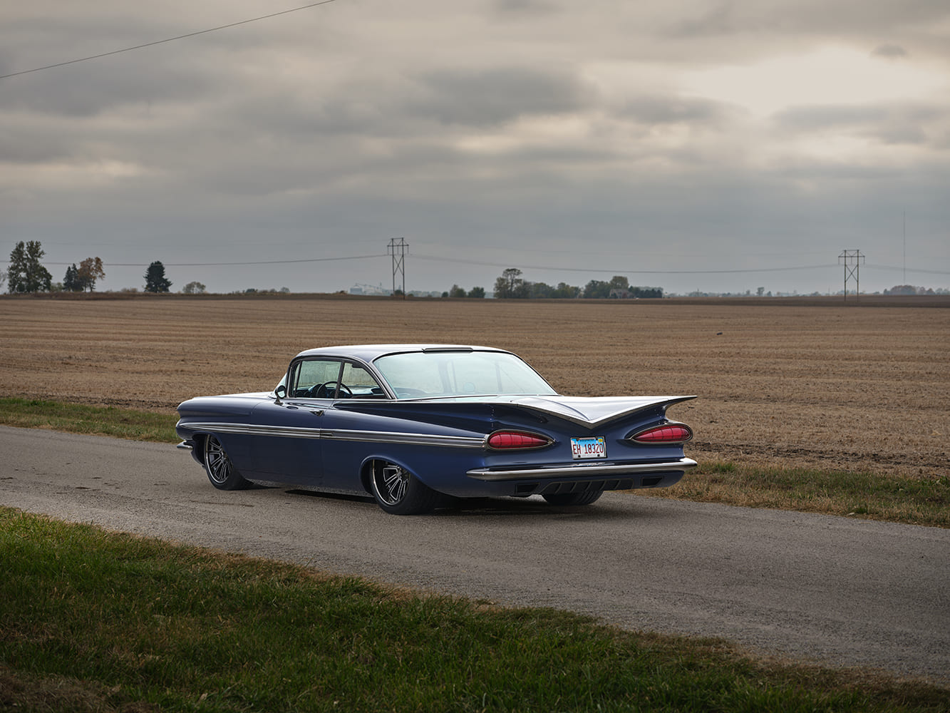 1959 Chevrolet Impala rear three quarter parked view custom coupe lowered stance tailfins country road