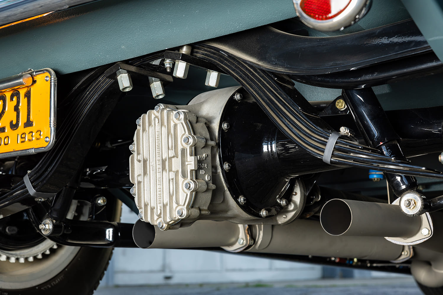 Underside view of a custom 1933 Ford hot rod showing the finned Winters quick change rear differential, transverse leaf spring, and exhaust system.