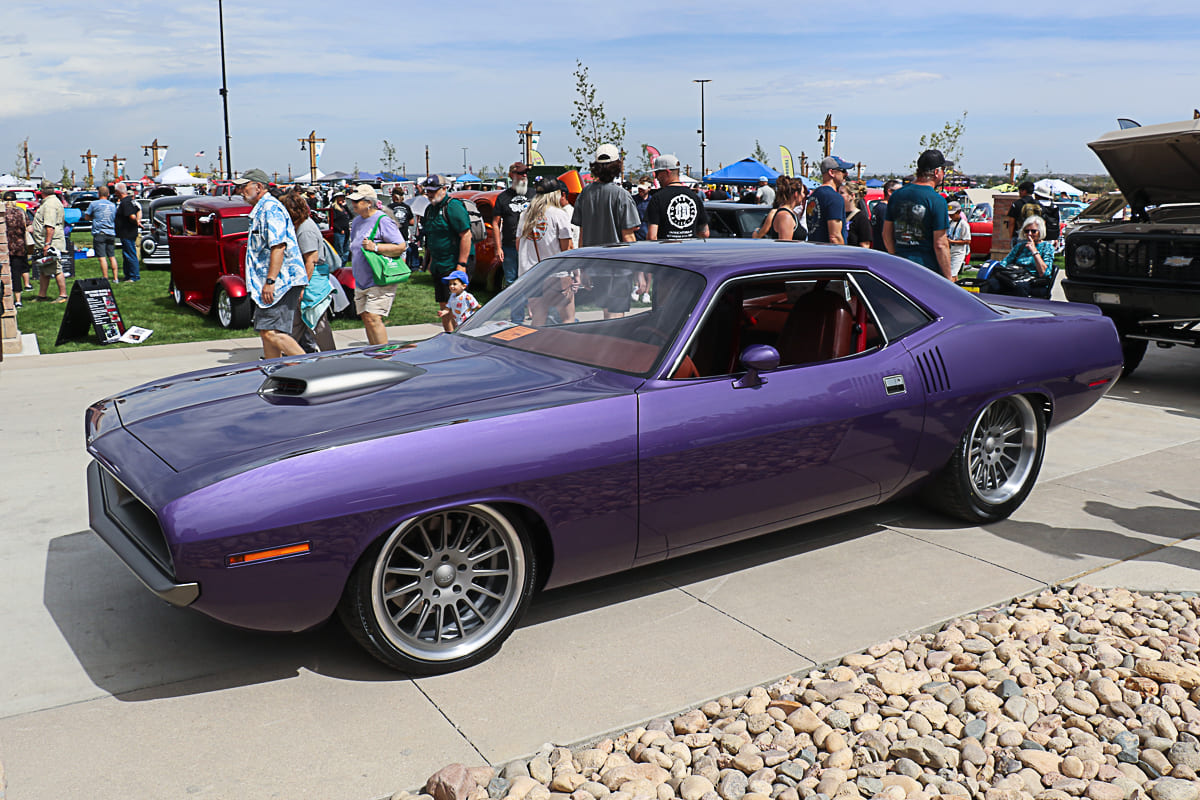 Front three-quarter angle of a slammed metallic purple 1970 Dodge Challenger featuring a Shaker hood scoop and polished mesh wheels at Goodguys Colorado.