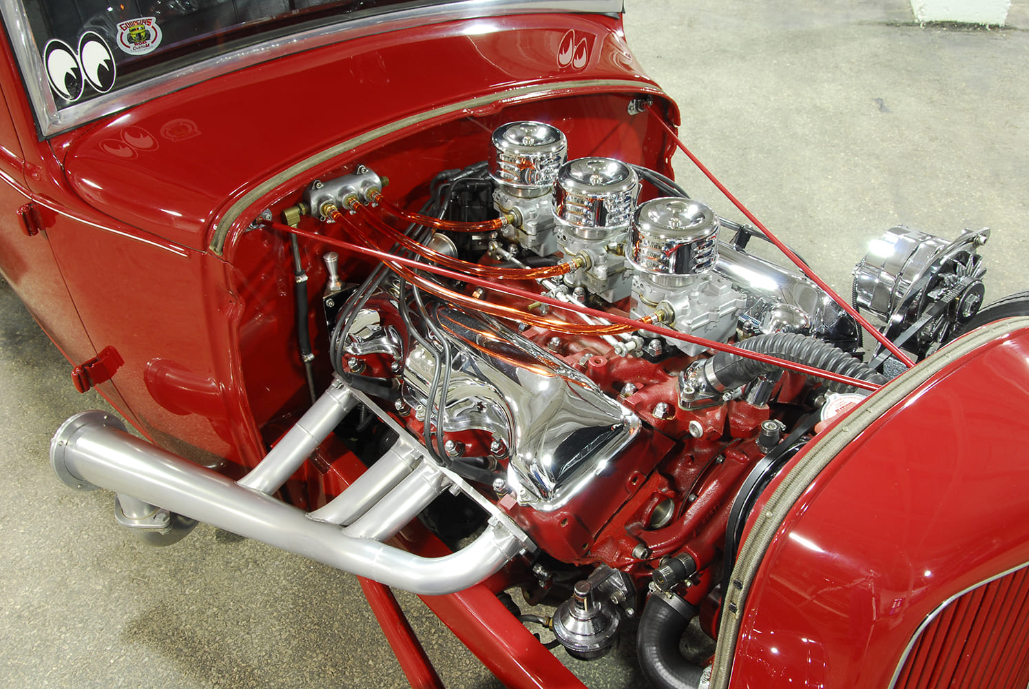 red hot rod with nostalgic 348 engine and triple carbs